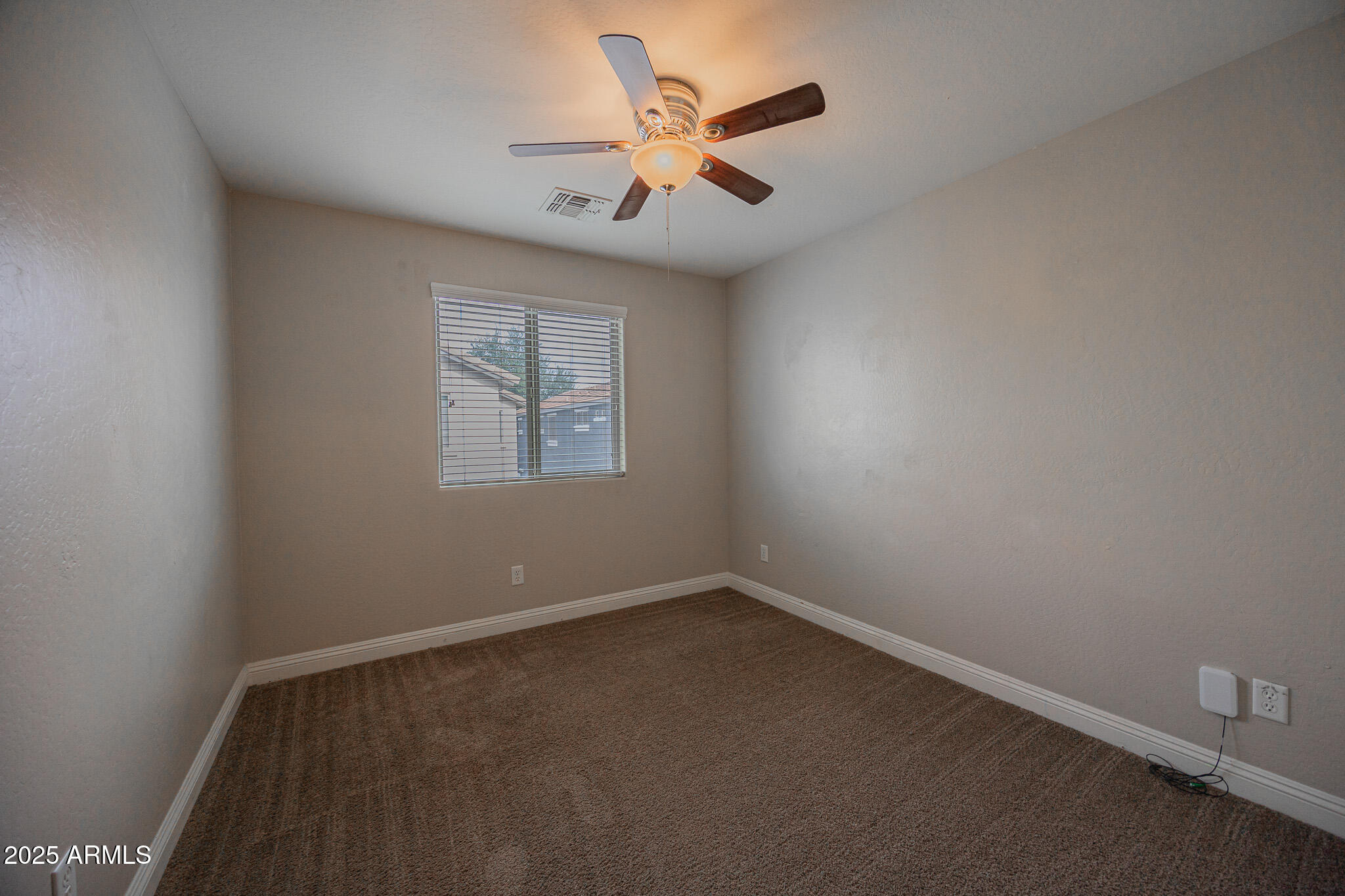 3314 East Sheffield Road Gilbert, AZ 85296 - Photo 23 of 31 an empty room with a window and a fan