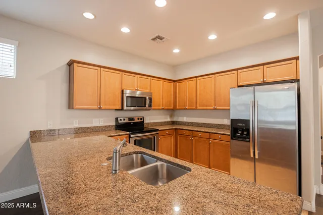 a kitchen with stainless steel appliances granite countertop a sink refrigerator and microwave