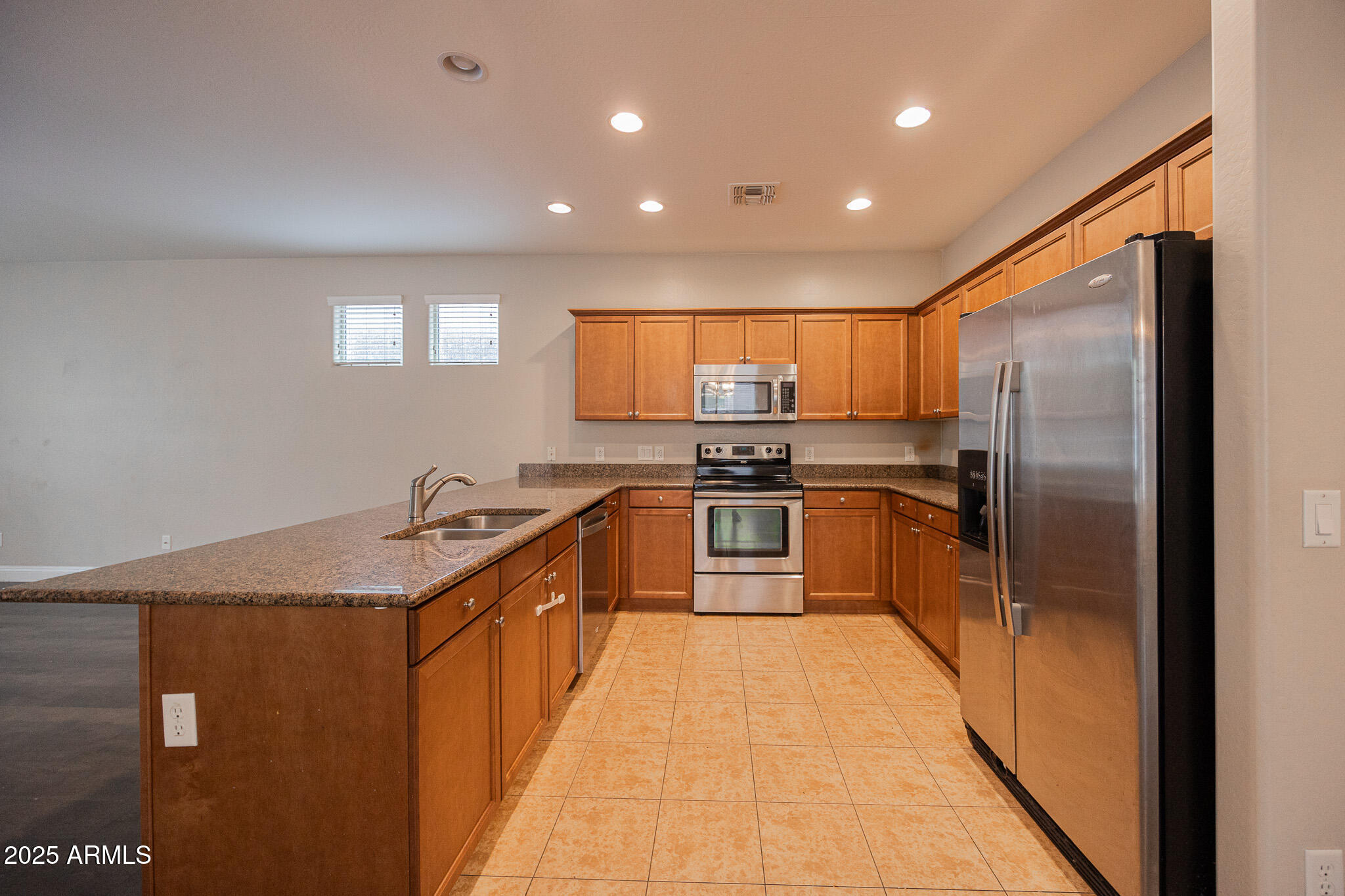 3314 East Sheffield Road Gilbert, AZ 85296 - Photo 8 of 31 a kitchen with kitchen island granite countertop a sink a counter top space stainless steel appliances and cabinets