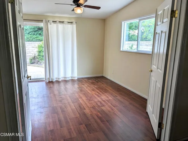 a view of a livingroom with wooden floor and a window