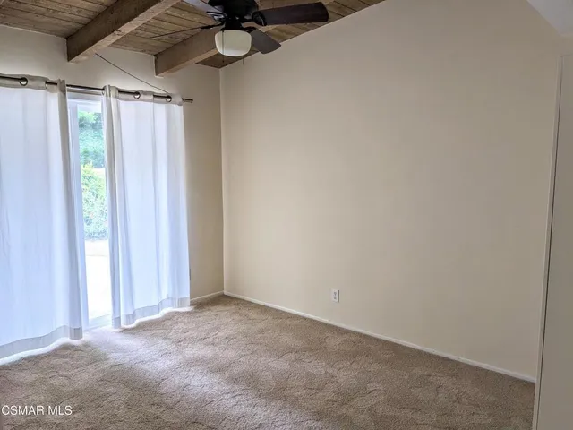 a view of a room with a window and a ceiling fan