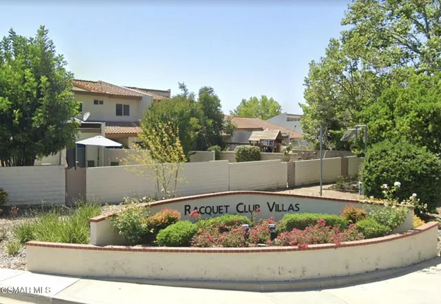 front view of a house with a yard and potted plants