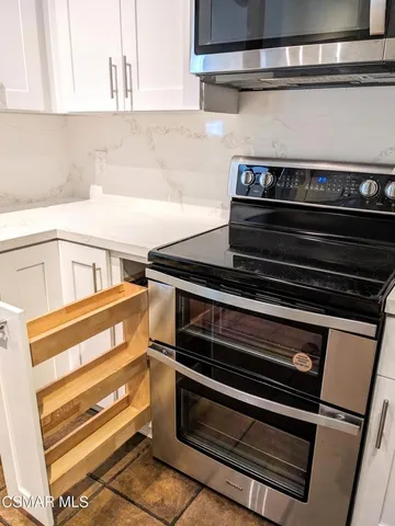 a stove top oven sitting inside of a kitchen