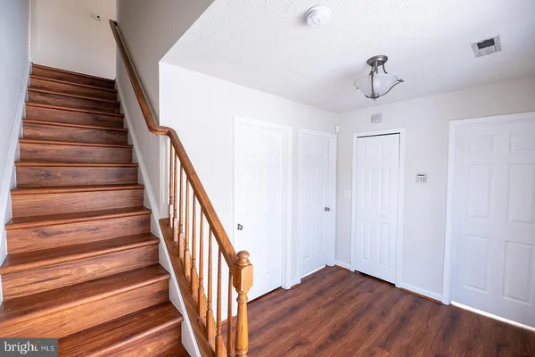 a view of staircase with wooden floor and white walls