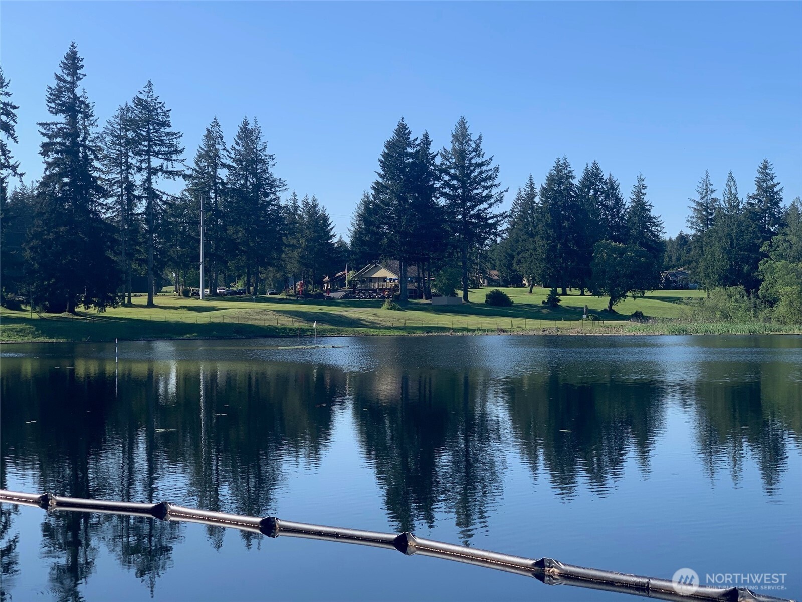 200 East Soderberg Road Allyn, WA 98524 - Photo 15 of 20 a view of a lake with a yard and a wooden fence