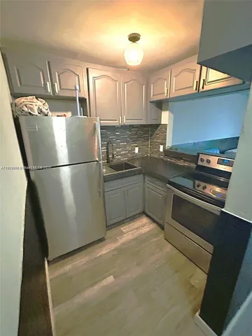 a kitchen with stainless steel appliances granite countertop a refrigerator a sink and a stove