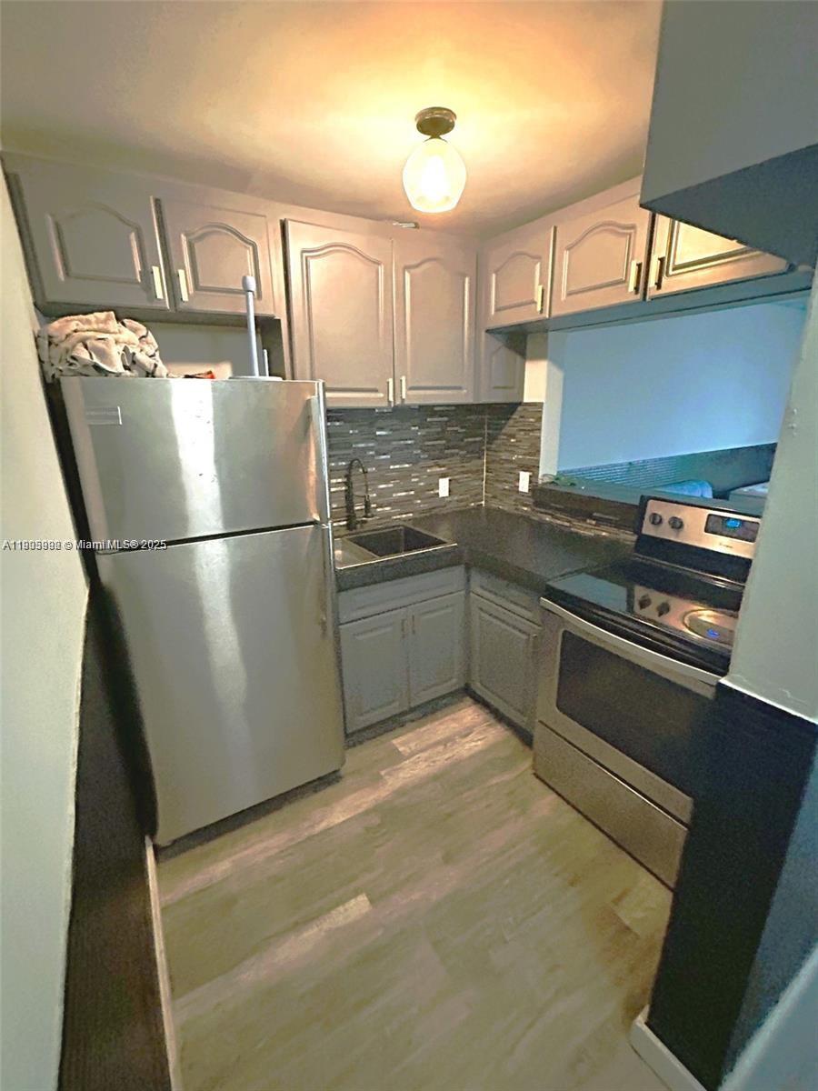 1441 Lincoln Road, Unit 217 Miami Beach, FL 33139 - Photo 1 of 15 a kitchen with stainless steel appliances granite countertop a refrigerator a sink and a stove