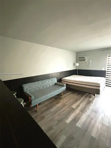 a view of a room with wooden floor and white walls