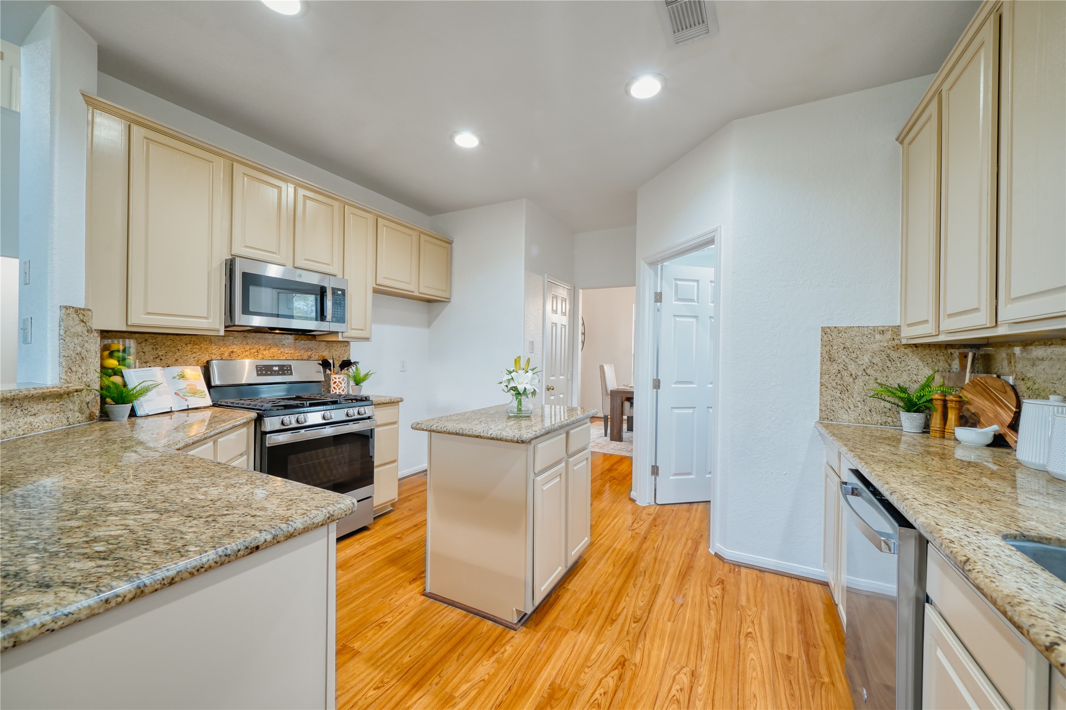 11115 Seminole Spring Lane Houston, TX 77089 - Photo 14 of 44 a kitchen with stainless steel appliances granite countertop a stove a sink dishwasher and a microwave oven with white cabinets