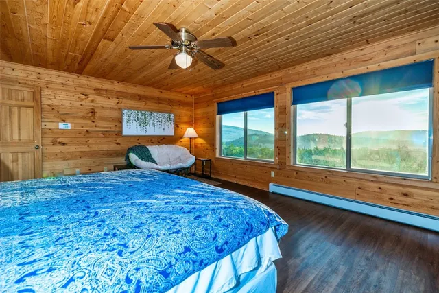 a bedroom with a bed and large window with outer view