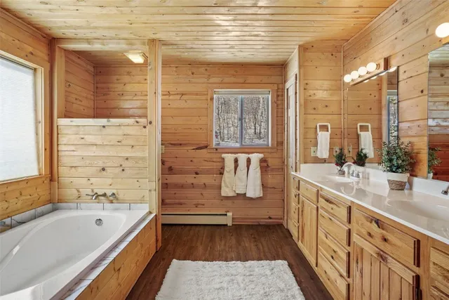 a bathroom with a tub sink and mirror