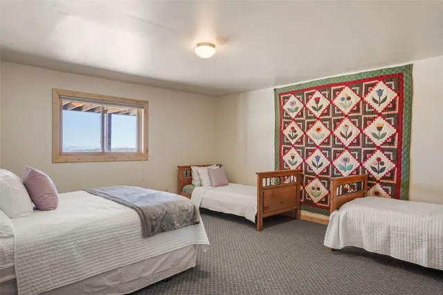 a bedroom with two beds and painting on the wall