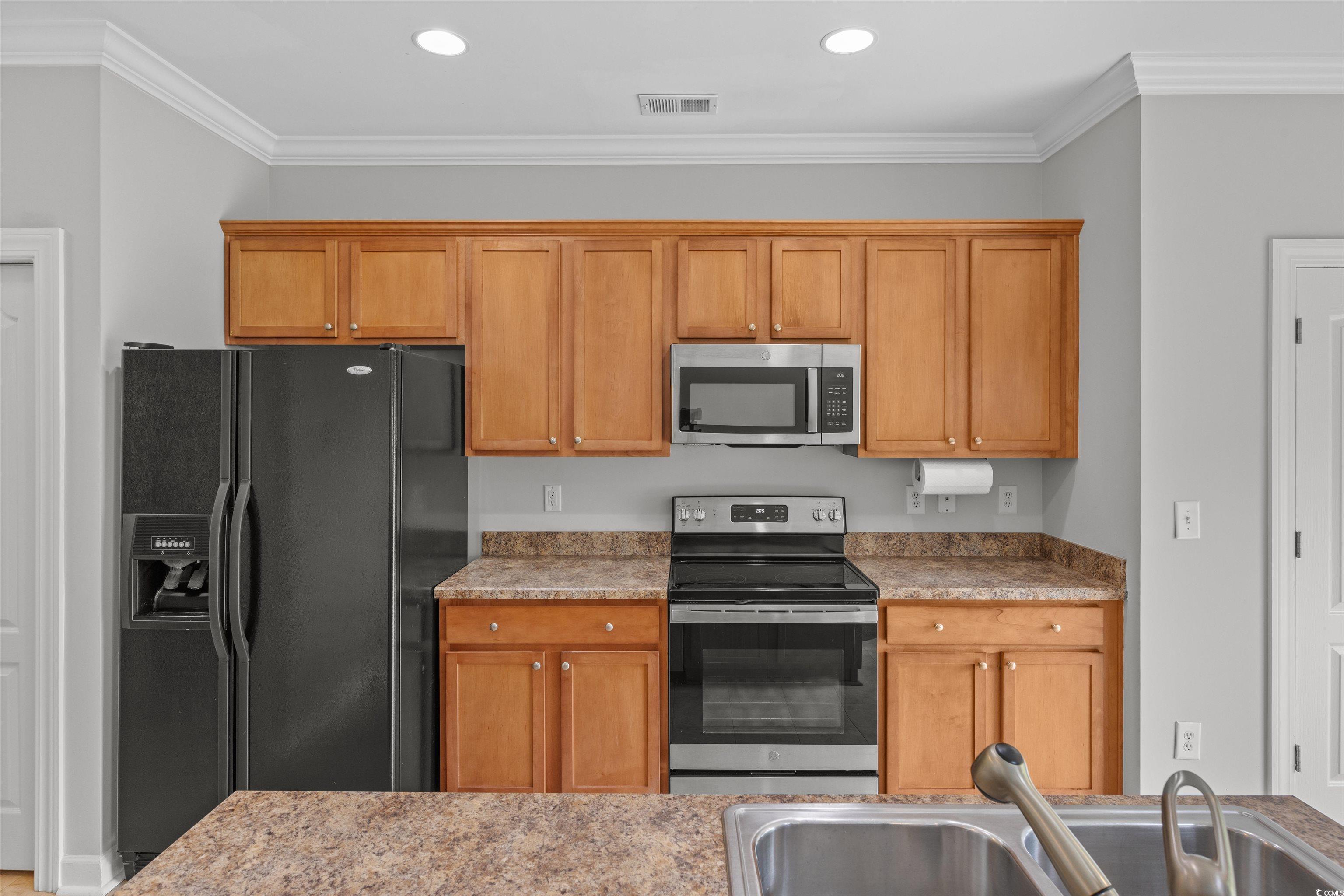 1060 Fairway Lane Conway, SC 29526 - Photo 11 of 32 Kitchen with stainless steel appliances, crown molding, brown cabinetry, light stone countertops, and recessed lighting
