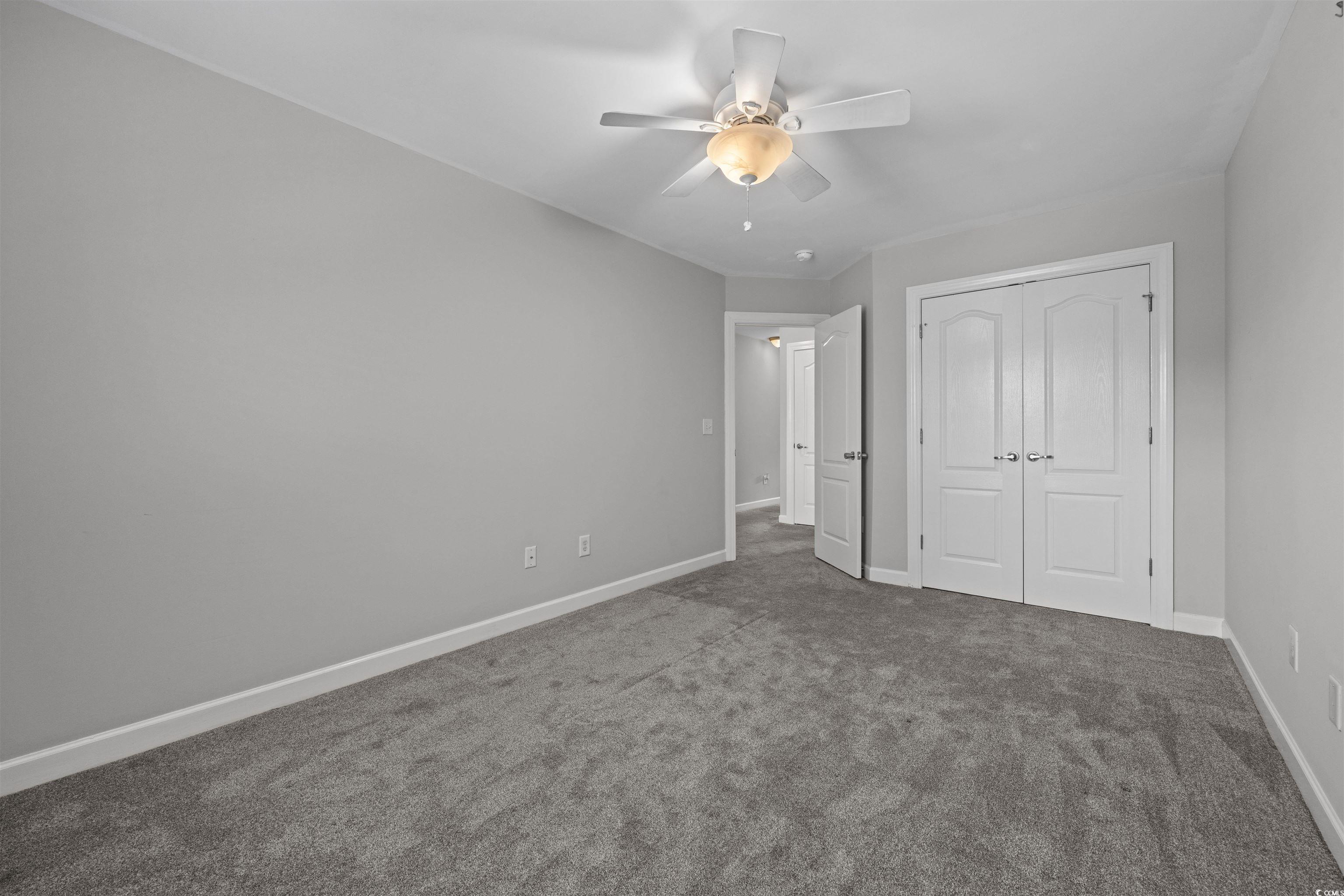 1060 Fairway Lane Conway, SC 29526 - Photo 15 of 32 Unfurnished bedroom with dark colored carpet, a closet, and a ceiling fan