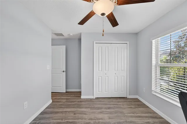 a bedroom with a bed and a ceiling fan