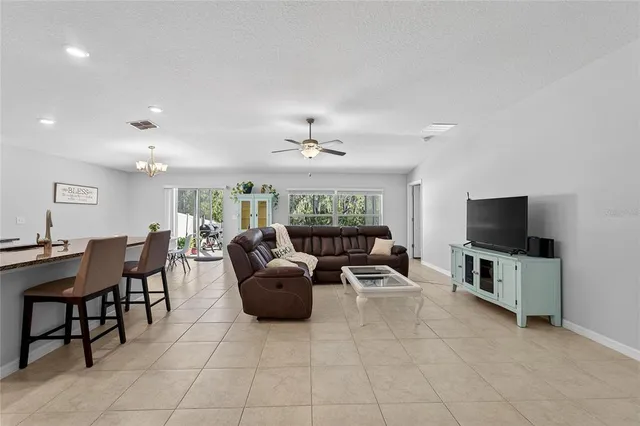 a kitchen with stainless steel appliances granite countertop a refrigerator a stove a sink a table and chairs