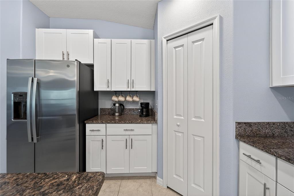 1728 Fred Ives Street Ruskin, FL 33570 - Photo 33 of 78 a kitchen with stainless steel appliances granite countertop a refrigerator a sink and white cabinets