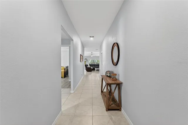 an empty room with wooden floor ceiling fan and windows