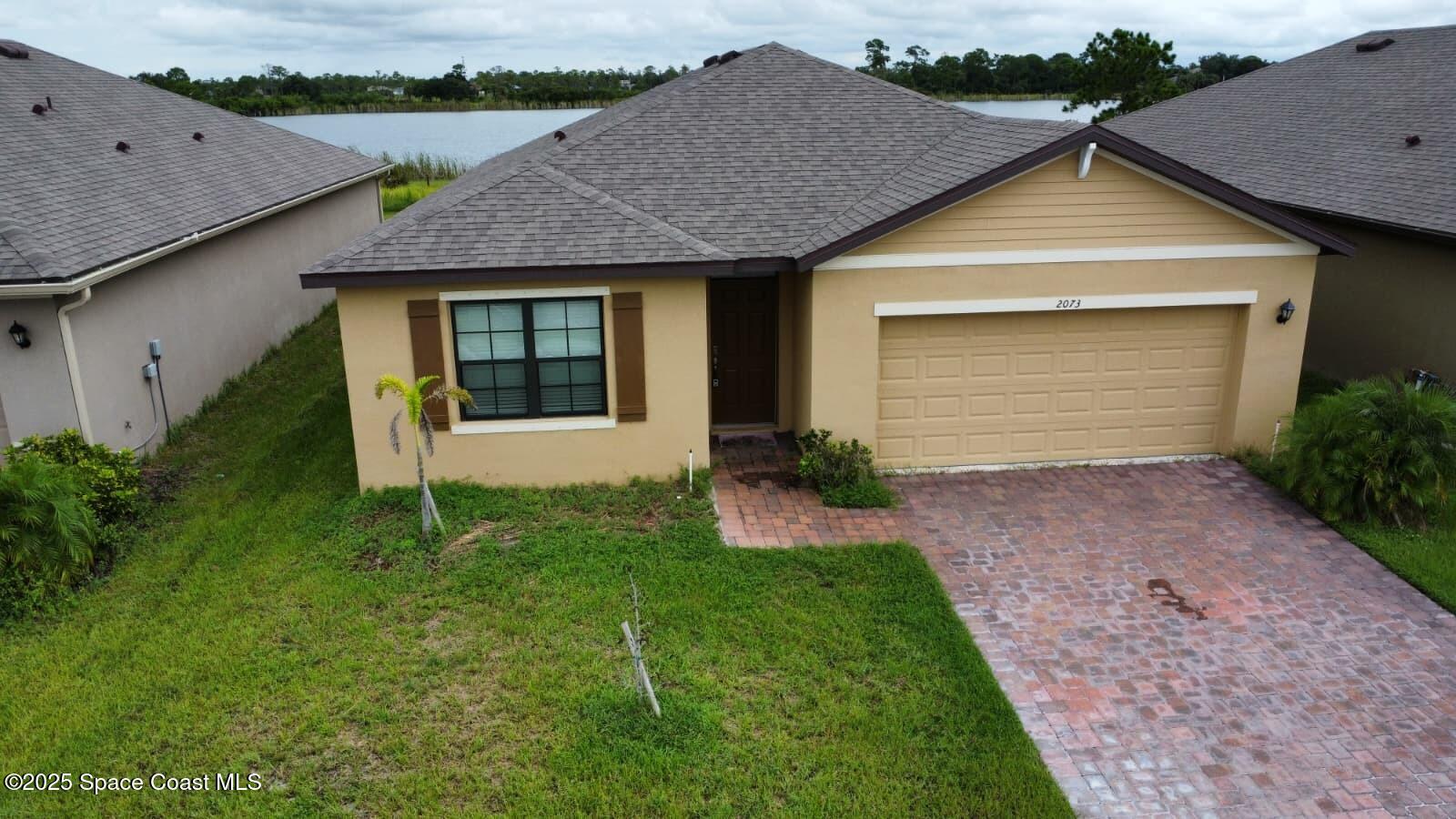 2073 Farmhouse Road Southeast Palm Bay, FL 32909 - Photo 1 of 14 a front view of a house with garden