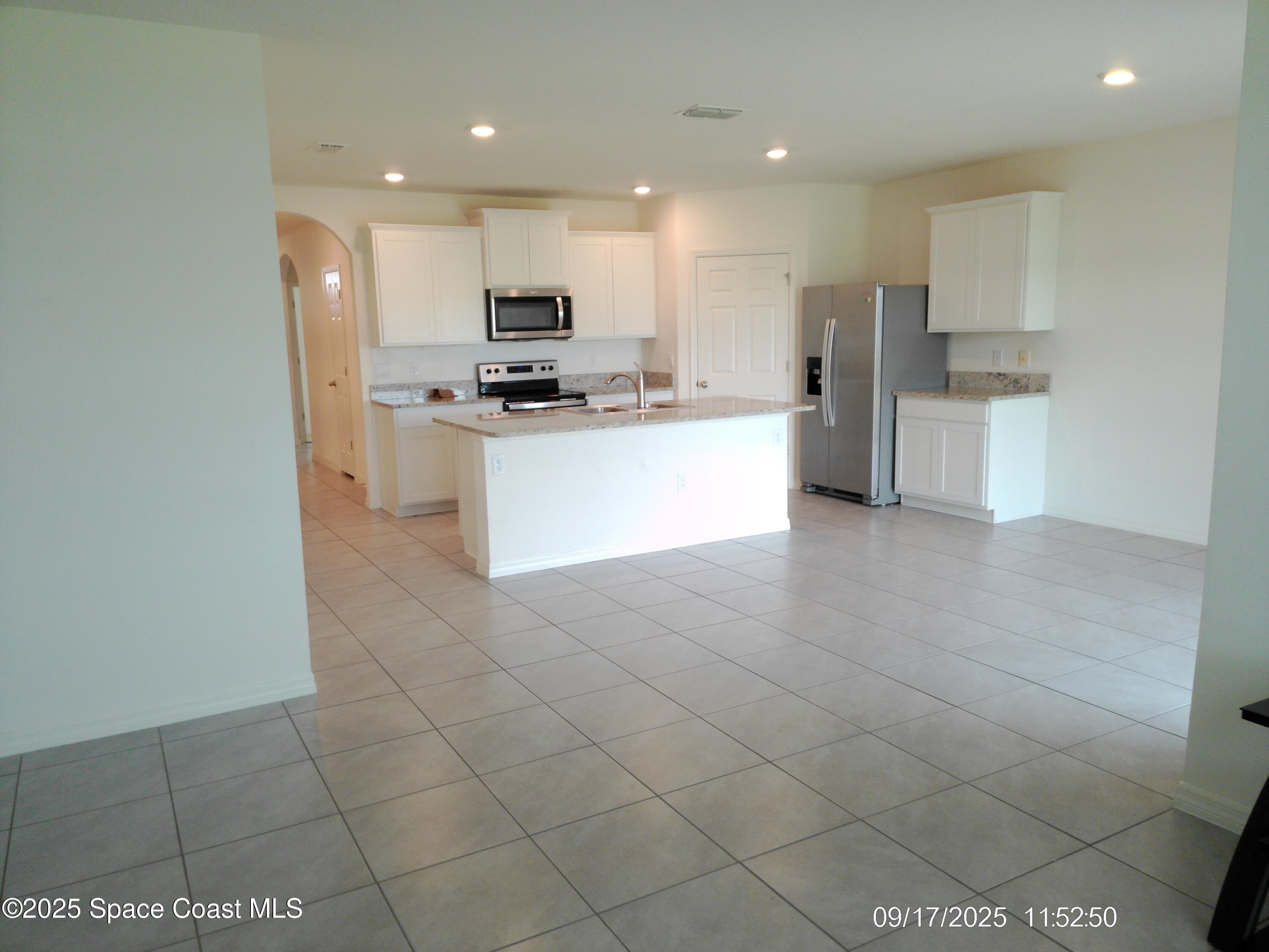 2073 Farmhouse Road Southeast Palm Bay, FL 32909 - Photo 7 of 14 a kitchen with stainless steel appliances kitchen island granite countertop a refrigerator and a stove top oven