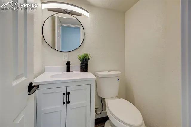 a bathroom with a toilet a sink and a mirror