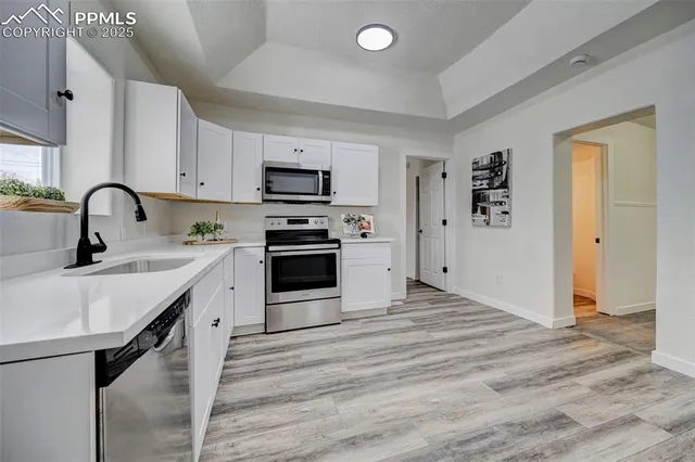 a kitchen with stainless steel appliances a sink stove and cabinets
