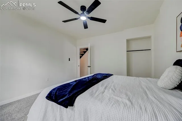 a bedroom with a bed and a ceiling fan
