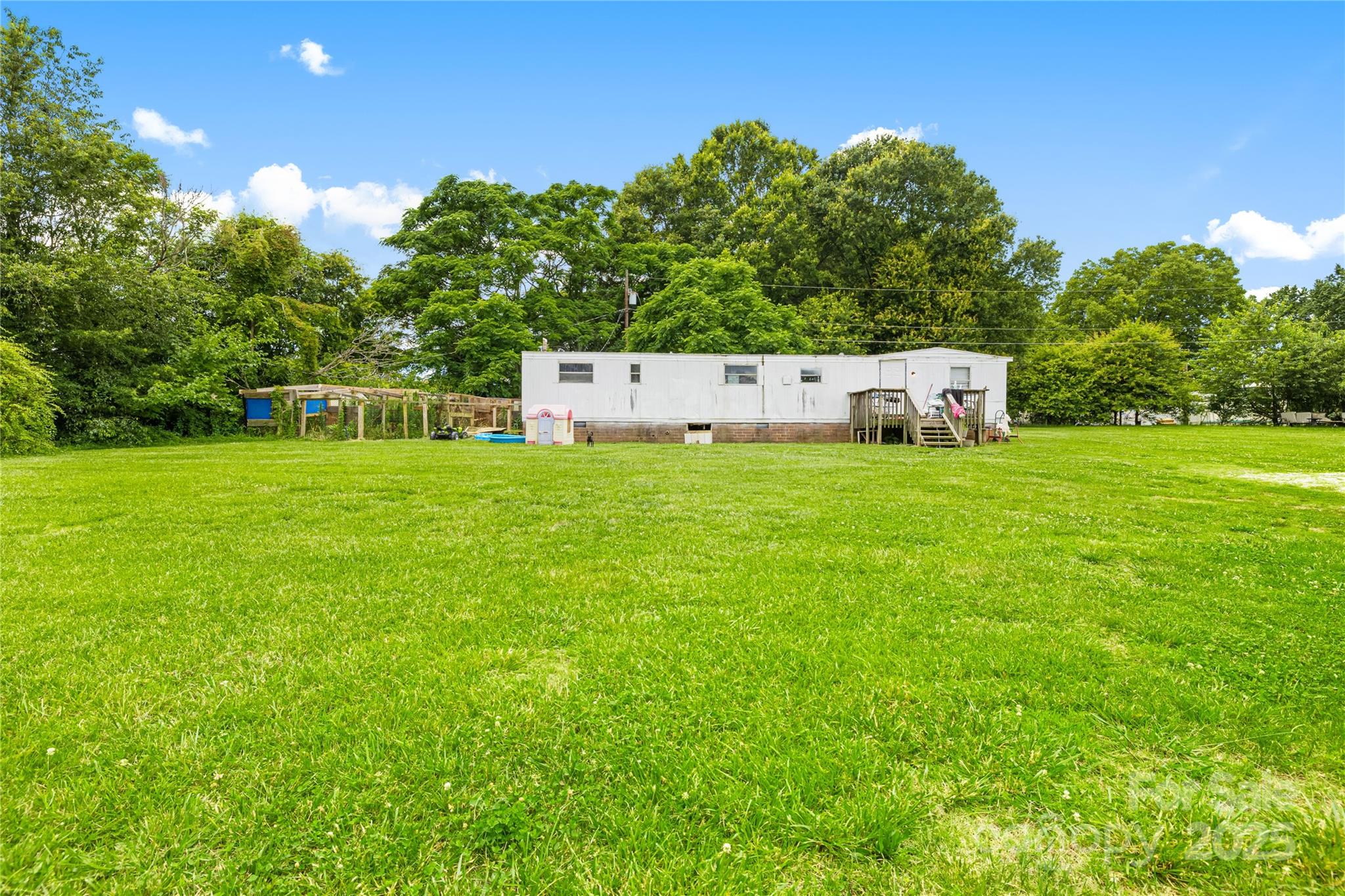 116 Webb Road Shelby, NC 28152 - Photo 12 of 15 a backyard of a house with plants and large trees