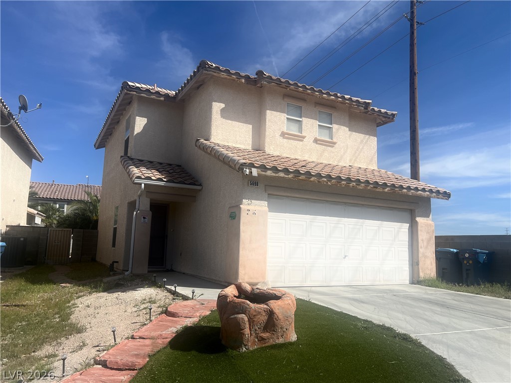 5698 Doubleday Street Las Vegas, NV 89118 - Photo 3 of 24 View of front of home featuring a garage, stucco siding, driveway, and a gate