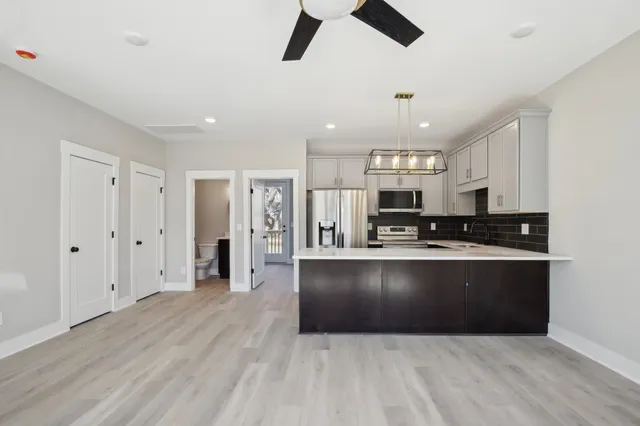 a large kitchen with stainless steel appliances granite countertop a refrigerator and a stove