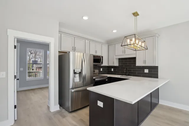a kitchen with refrigerator cabinets and wooden floor