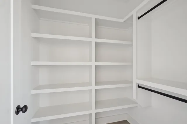 a view of walk in closet with empty racks