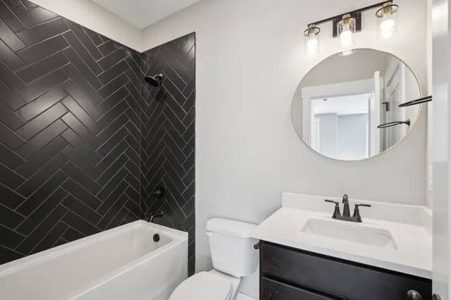 a bathroom with a sink vanity mirror and bathtub