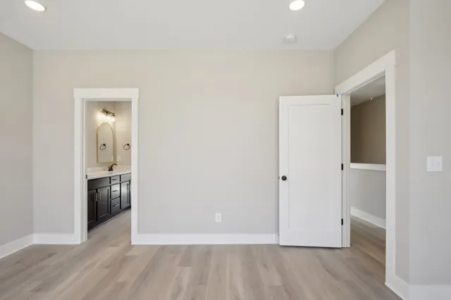 a view of an empty room with wooden floor & closet