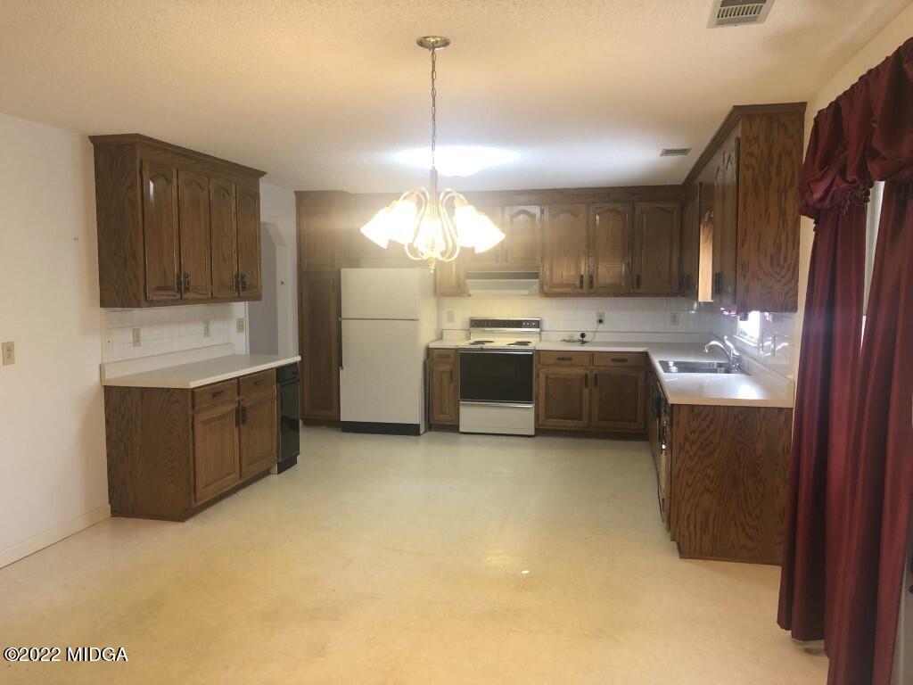 1589 Hamlin Road Lizella, GA 31052 - Photo 4 of 25 a kitchen with stainless steel appliances granite countertop a stove and a sink