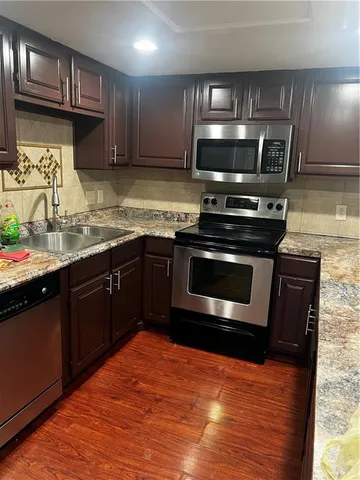a kitchen with stainless steel appliances granite countertop a stove a sink and a microwave