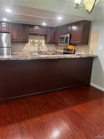 a kitchen with granite countertop a sink a stove and cabinets
