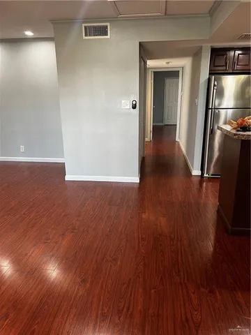 a view of a room with wooden floor staircase and a kitchen