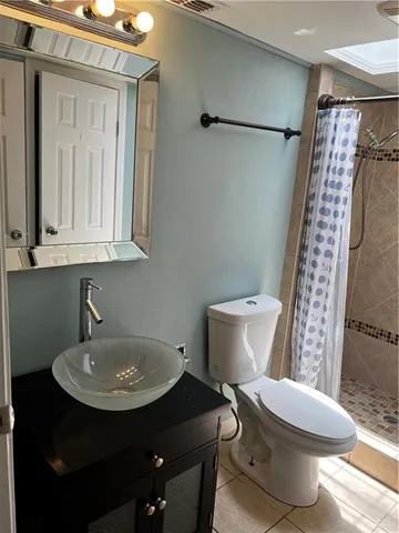a bathroom with a sink a toilet a shower and a mirror