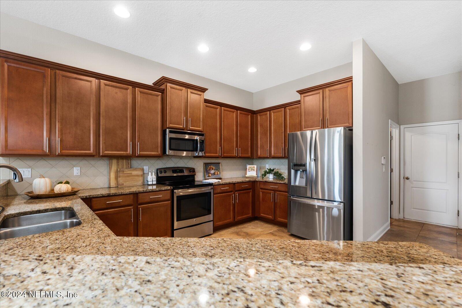 273 Parkwood Circle St. Augustine, FL 32086 - Photo 13 of 34 a kitchen with stainless steel appliances granite countertop a refrigerator stove top oven and sink