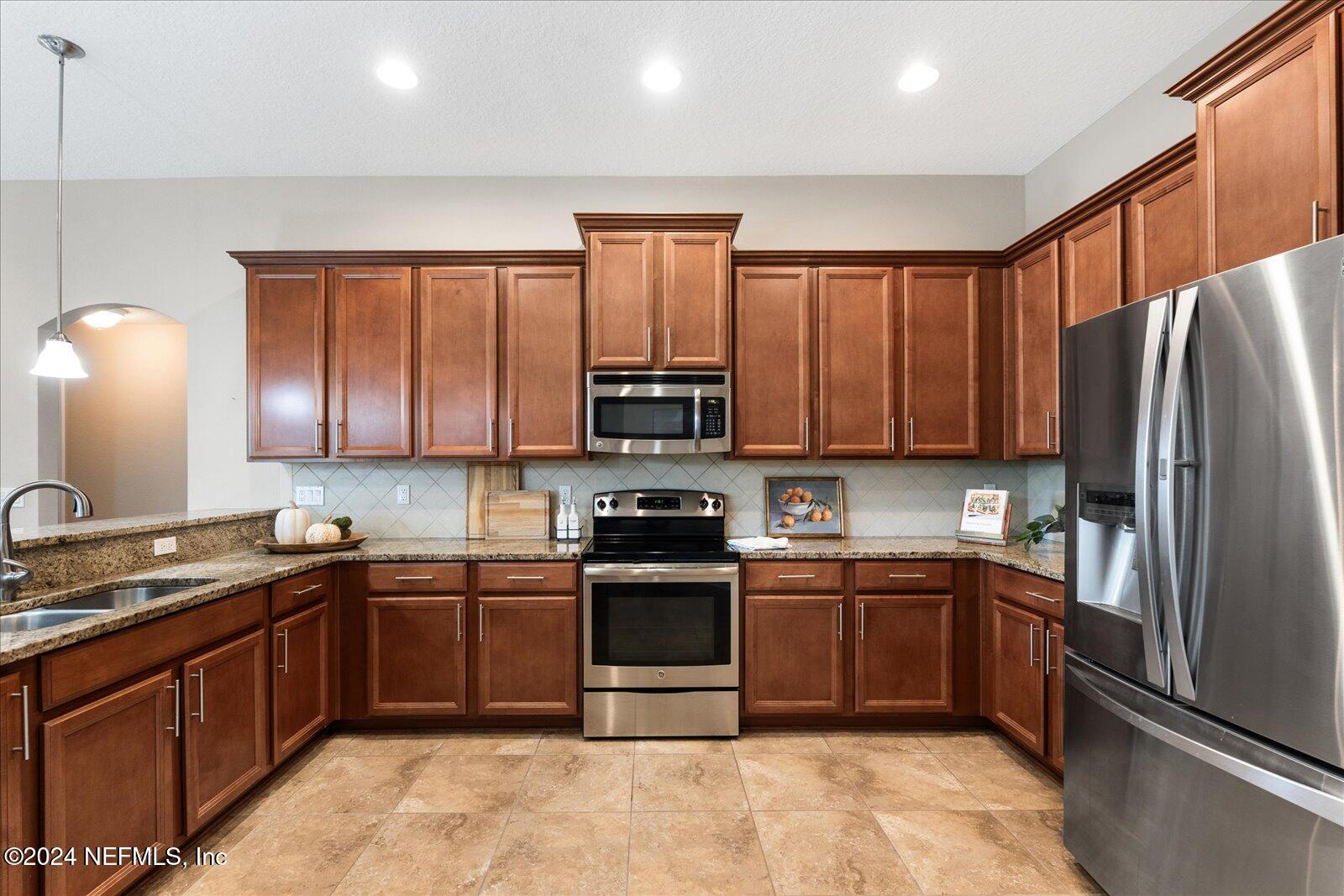 273 Parkwood Circle St. Augustine, FL 32086 - Photo 14 of 34 a kitchen with stainless steel appliances granite countertop a sink stove and refrigerator