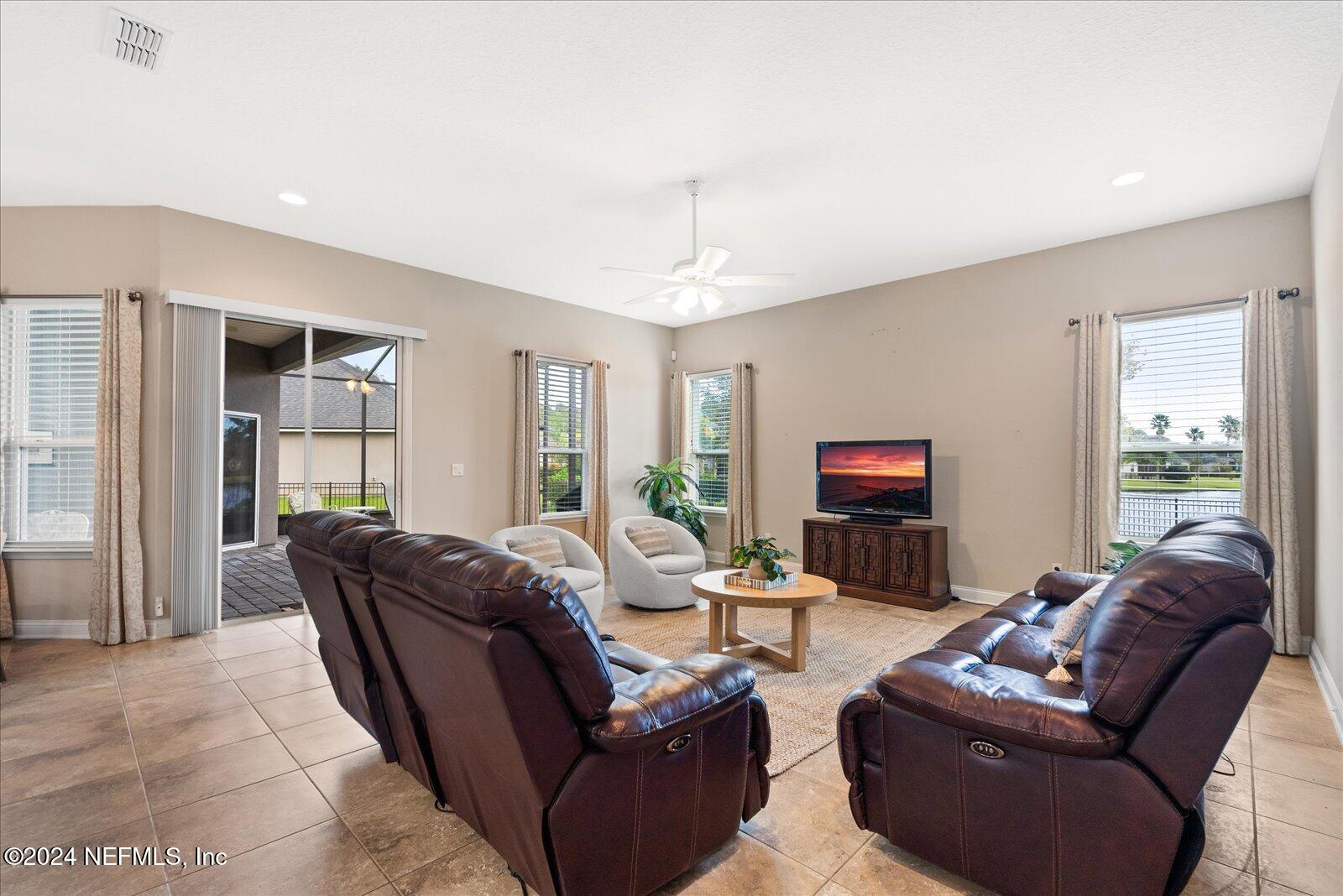 273 Parkwood Circle St. Augustine, FL 32086 - Photo 16 of 34 a living room with furniture a flat screen tv and a large window