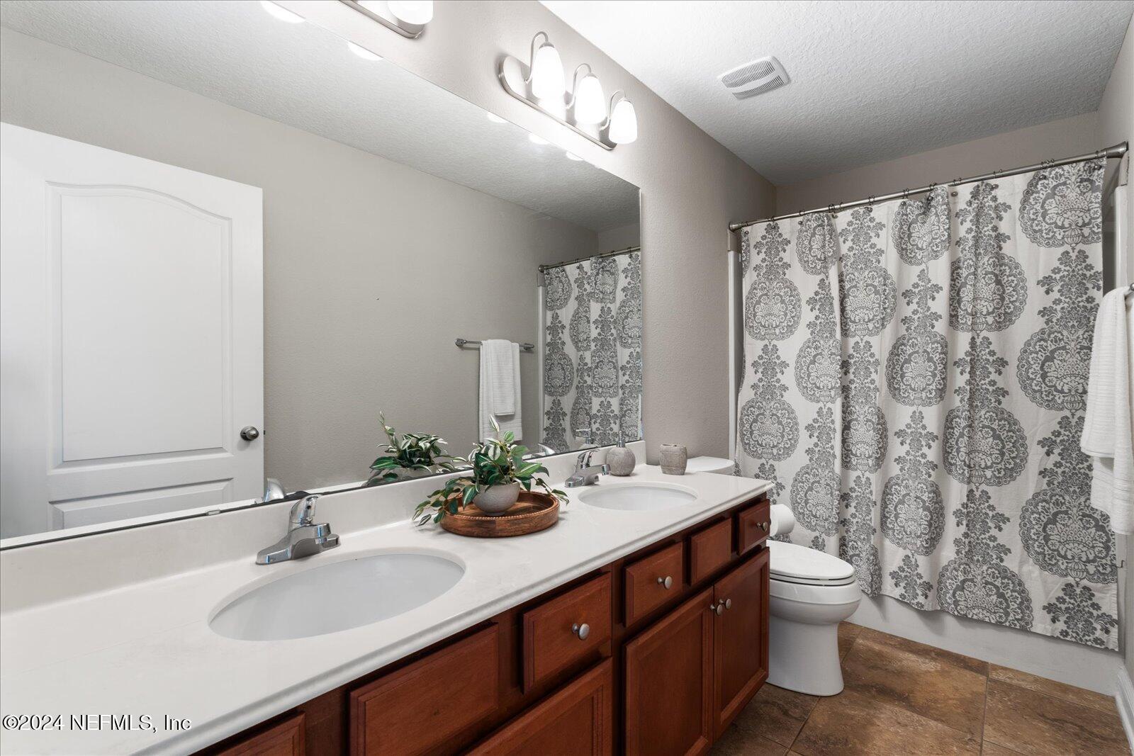 273 Parkwood Circle St. Augustine, FL 32086 - Photo 23 of 34 a bathroom with double sink and a mirror