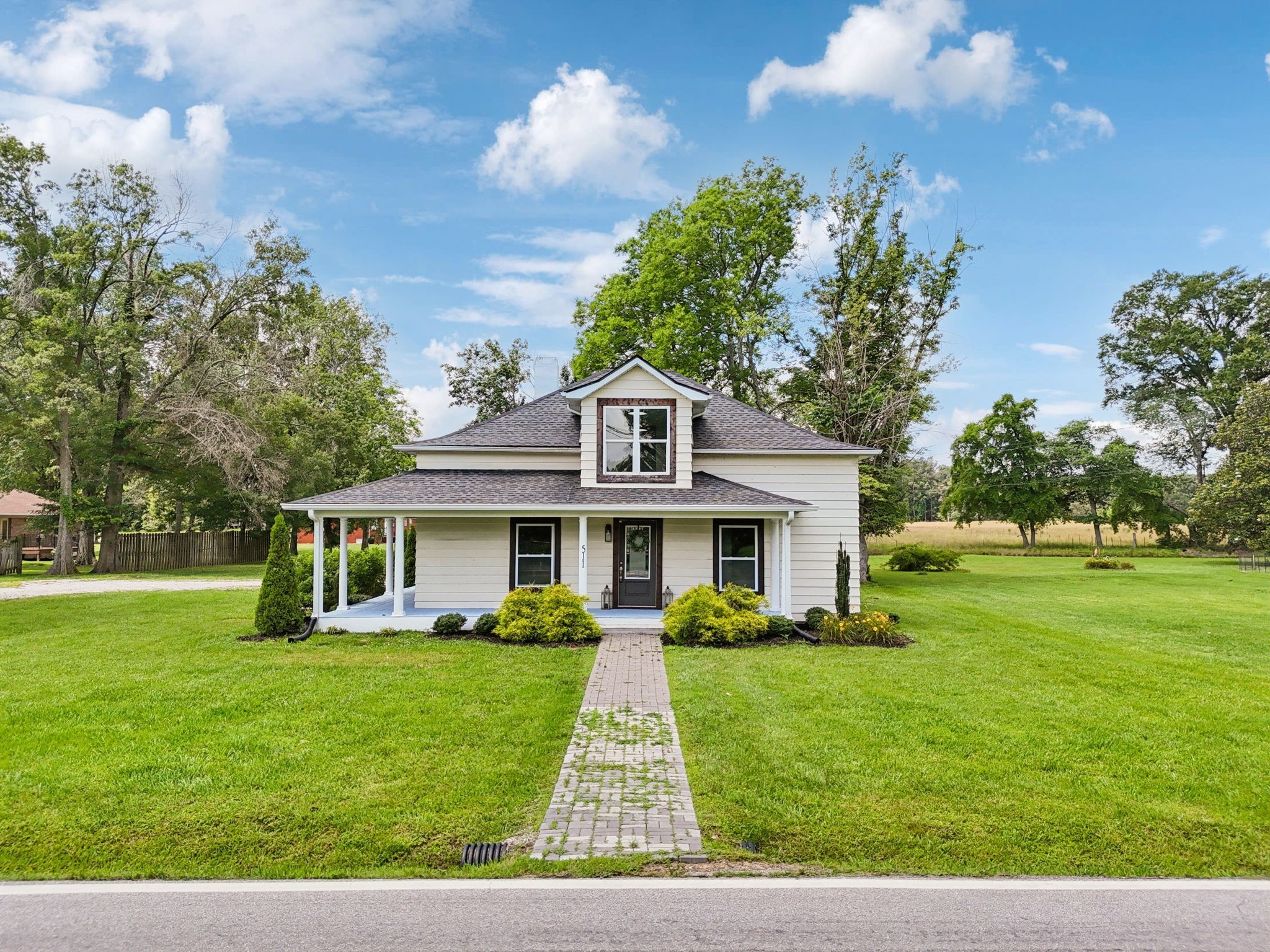 511 North Main Street Morrison, TN 37357 - Photo 3 of 41 a front view of a house with a garden and trees