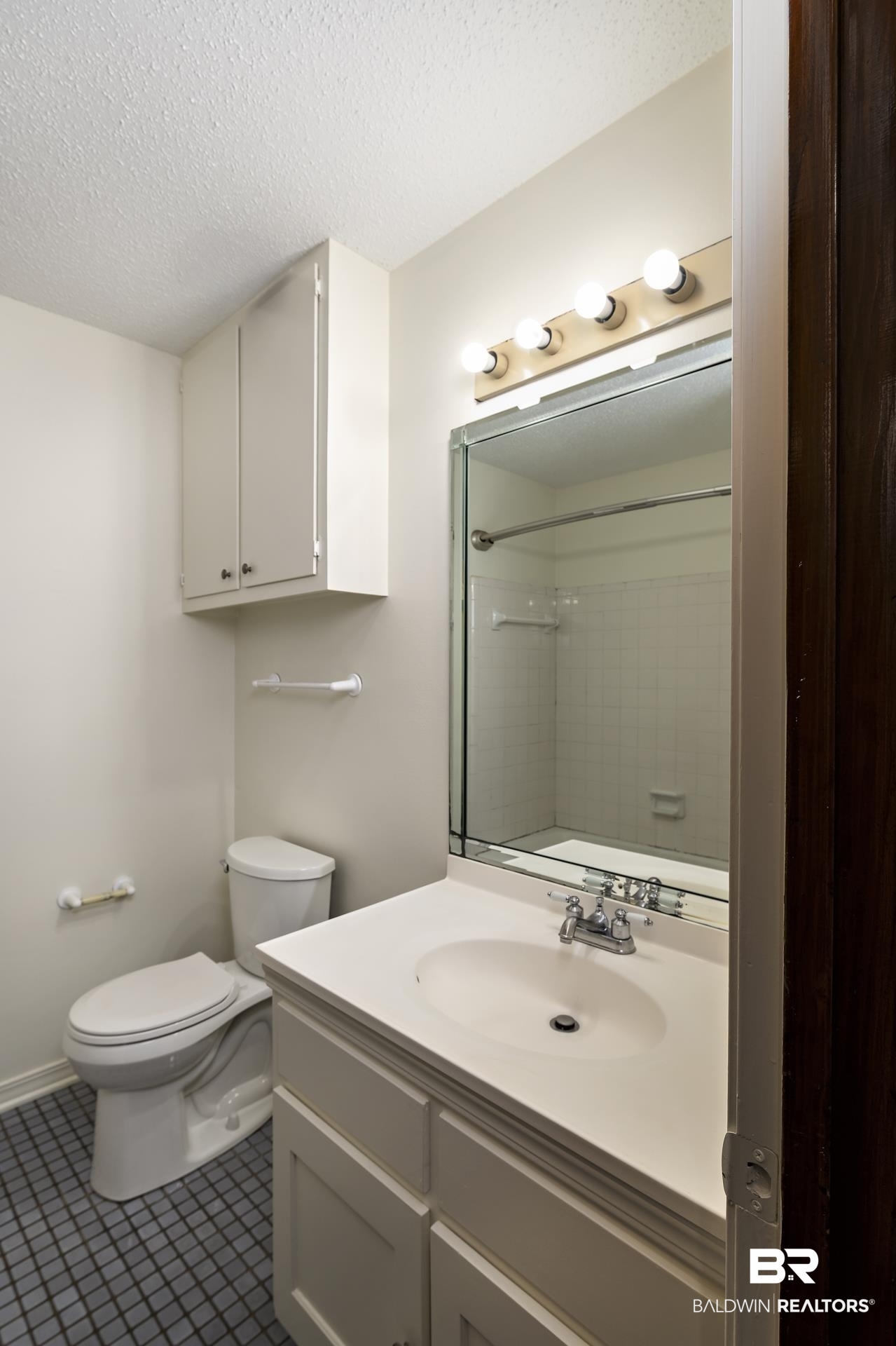 707 Johnson Avenue Fairhope, AL 36532 - Photo 22 of 38 Bathroom with a textured ceiling, vanity, toilet, a shower, and baseboards