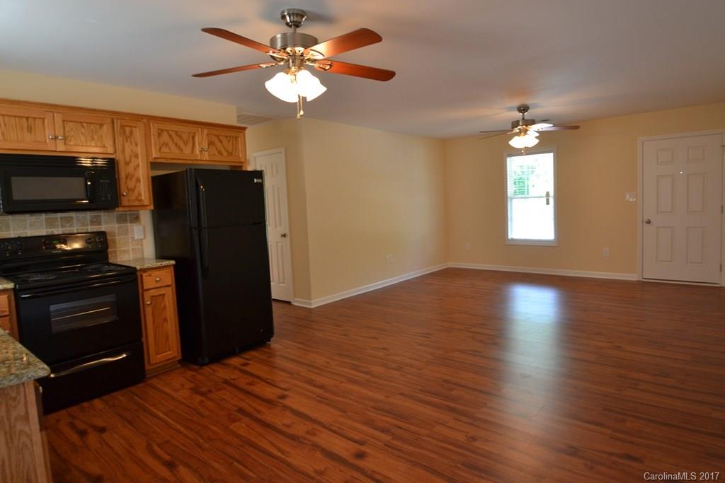 3835 Lee Moore Road, Unit 3835 Maiden, NC 28650 - Photo 7 of 19 a view of a kitchen with a stove a ceiling fan and wooden floor