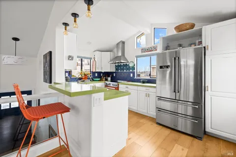 a kitchen with kitchen island a refrigerator and a stove