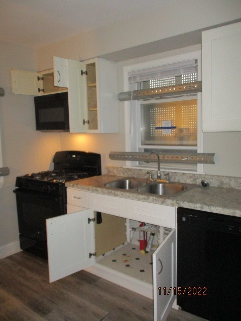 415 West 99th Place Chicago, IL 60628 - Photo 6 of 14 a kitchen with stainless steel appliances granite countertop a sink dishwasher stove and microwave with wooden cabinets