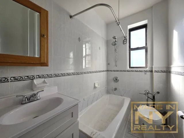 a bathroom with a tub sink and mirror