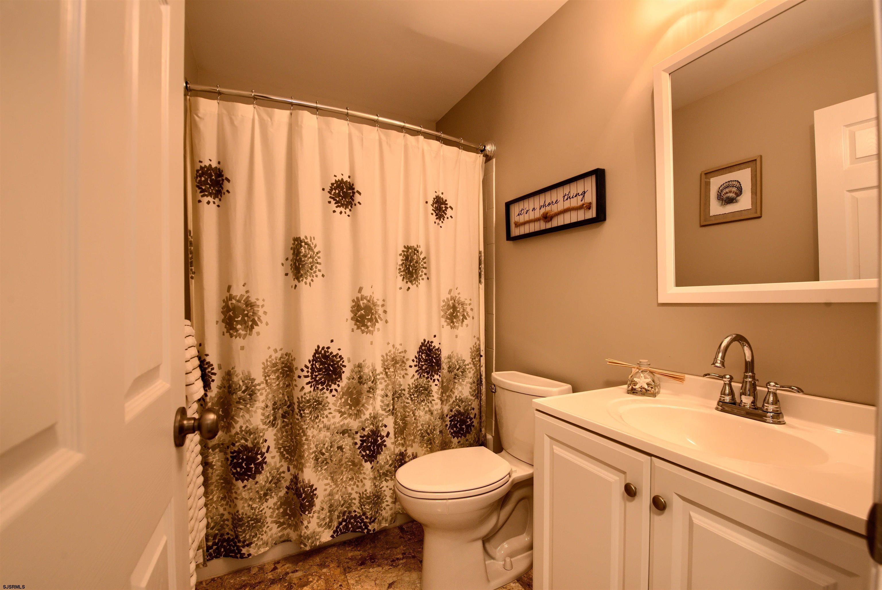 167 40th Street South, Unit 2 Brigantine, NJ 08203 - Photo 20 of 28 a bathroom with a sink a toilet and a mirror